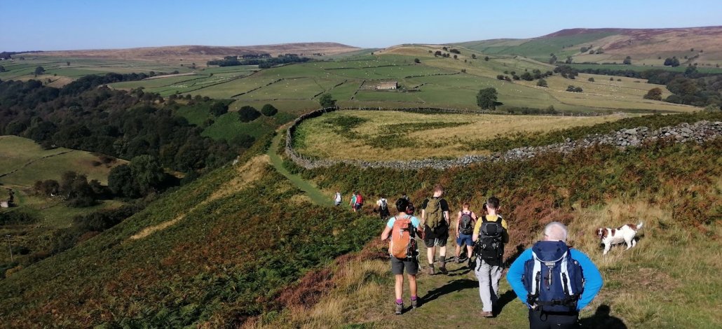 Eyam Moor Walk walkers descending from Eyam Moor in the Peak District