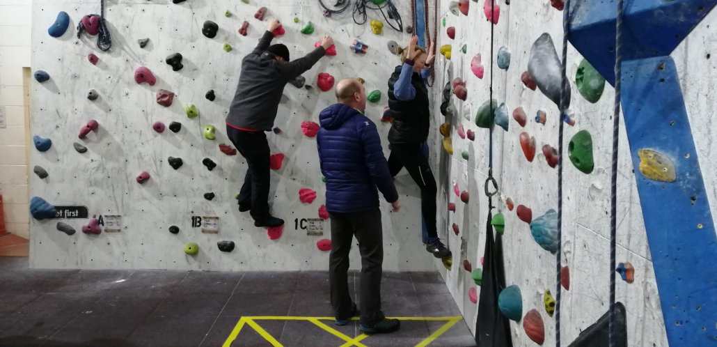 A fear of heights and learning the fundamentals of rock climbing People with a fear of heights practising the fundamentals of rock climbing just above floor level
